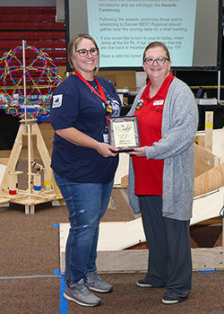 Robin Coleman, Arnett High School robotics team (left), is awarded Coach of the Year by Heartland BEST co-director Dr. Jenny Sattler (right).