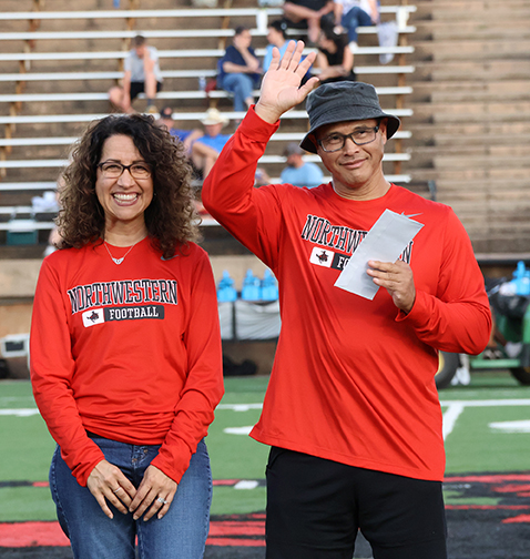 Lisa Cal (left) and Dennis Cal (right) accept a $300 scholarship prize on behalf of their son Wilson Cal during halftime of the Family Day Football game against Southeastern Oklahoma State University on Sept. 28.