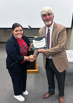 Mattie Pitts (left), senior Elementary Education major from Waynoka, receives her award from Dr. James Bell (right). 