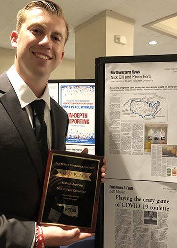 Northwestern News reporter Nick Dill shows off his and Kevin Ford’s first place plaque while standing next to a digital tear-sheet of their award-winning in-depth story on recycling during the 2021 Oklahoma Press Association's annual awards convention June 12 in Oklahoma City.