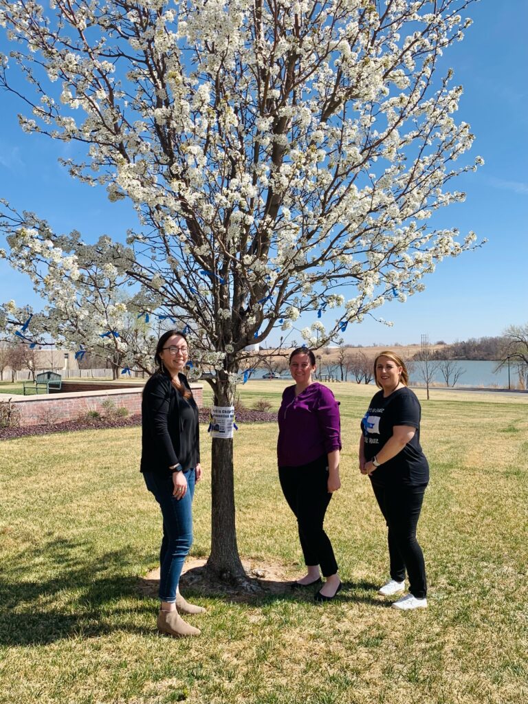 Pictured are (left to right) Jewel Shepherd, senior SWAT member; Katie Gardner, senior SWAT member; and Codi Harding, SWAT sponsor, with the blue ribbon tree at the Northwestern-Woodward campus.