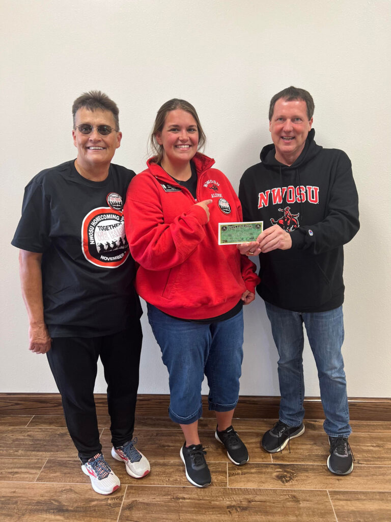 (Left) Karen Koehn, homecoming button chair, and Dr. David Pecha, university executive vice president and homecoming chair, presented the $1,000 in Alva Chamber Bucks to button winner, Erin Davis.